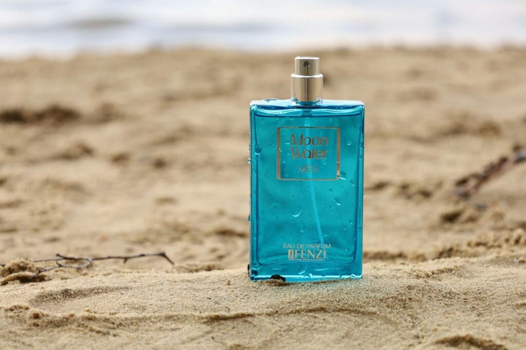 A collection of fresh summer perfumes for men, including citrusy and aquatic fragrances, displayed on a wooden surface with summer elements like lemons and sea shells.