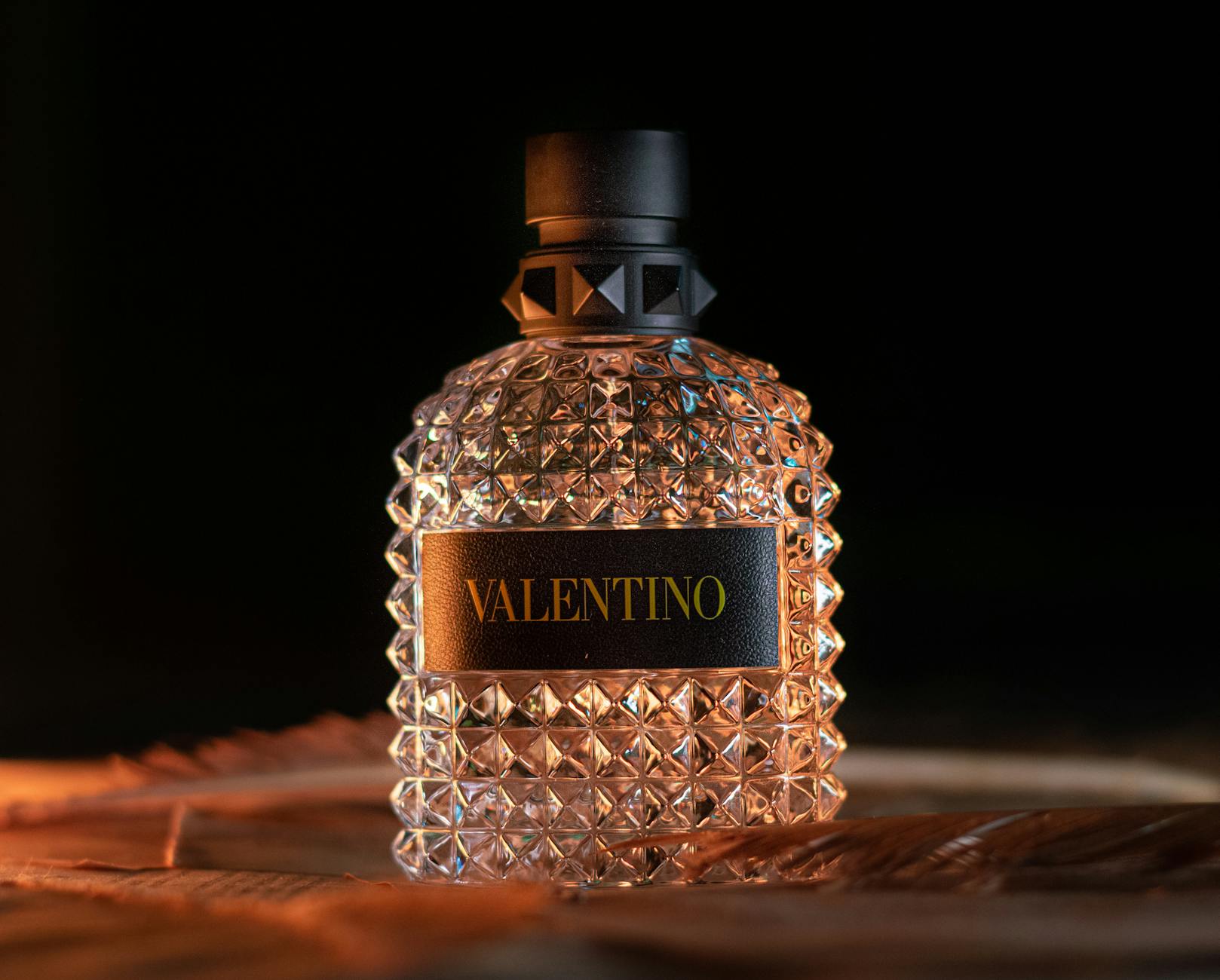 A man applying a seductive date night perfume on his wrist in a romantic setting.