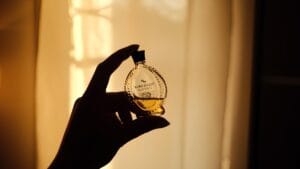 Elegant woman choosing a winter perfume in a snowy city setting, showcasing luxury and affordable fragrance options for cold weather.