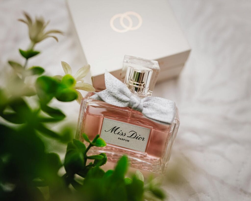 A collection of the best Dior perfumes for women, including J’adore, Miss Dior, and Hypnotic Poison, displayed on a marble vanity with golden accents.