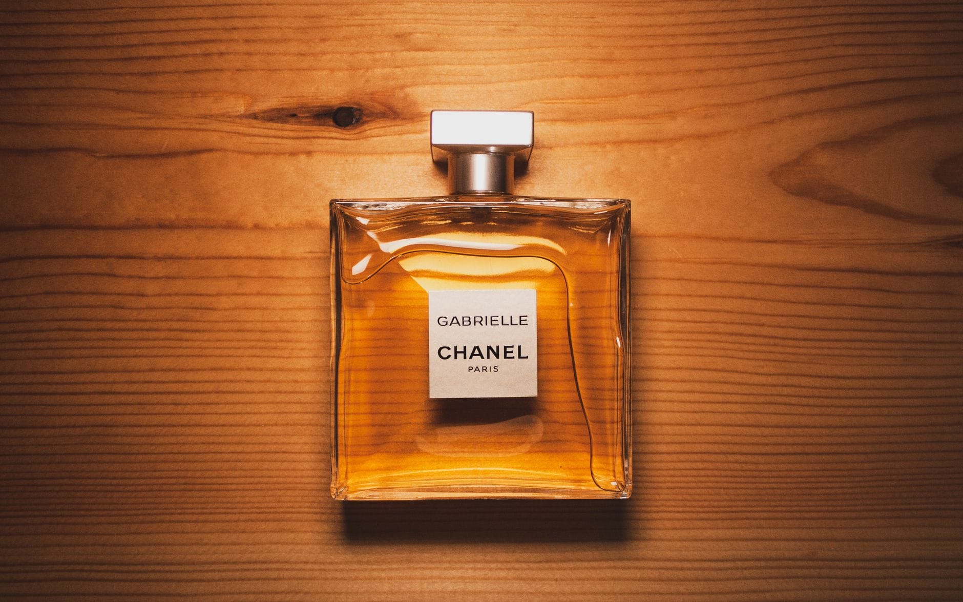 Comparison of Dior Sauvage and Bleu de Chanel perfume bottles with a stylish male model in the background.