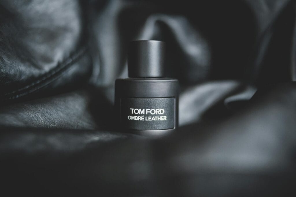 Tom Ford Oud Wood perfume bottle with a dark wooden background, representing luxury woody fragrances