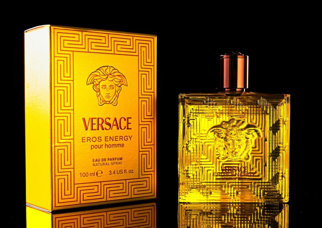Versace Eros perfume bottle with mint leaves and vanilla pods, representing the fragrance's fresh and seductive notes for men.