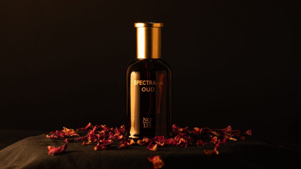 A collection of luxury Middle Eastern oud perfume bottles for men on a dark rustic stone surface with warm golden lighting