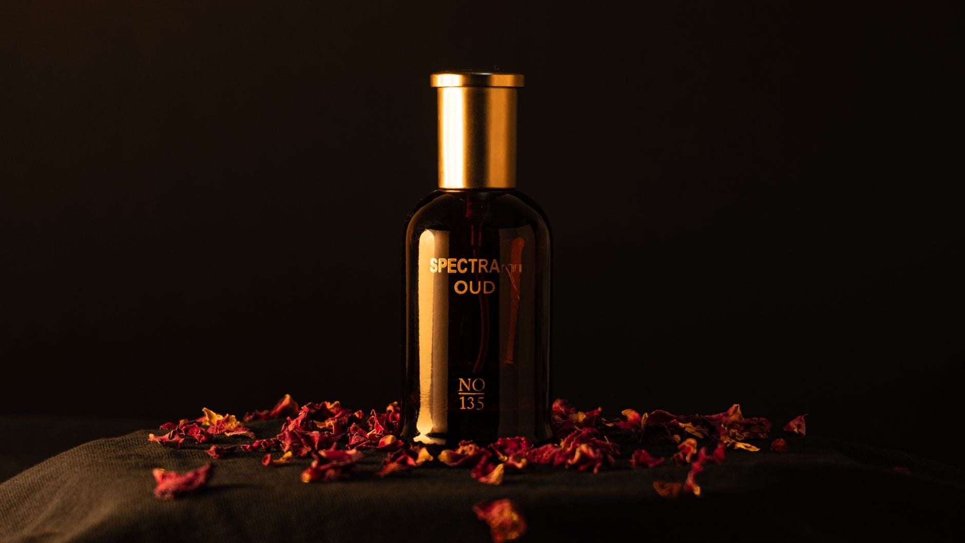 A collection of luxury Middle Eastern oud perfume bottles for men on a dark rustic stone surface with warm golden lighting