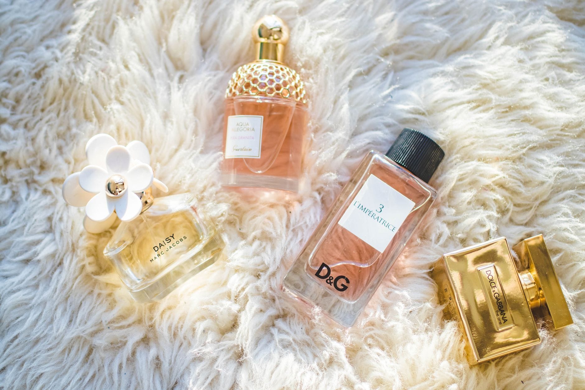 A collection of luxury perfume bottles on a clean marble surface, symbolizing quiet luxury and wealthy scents