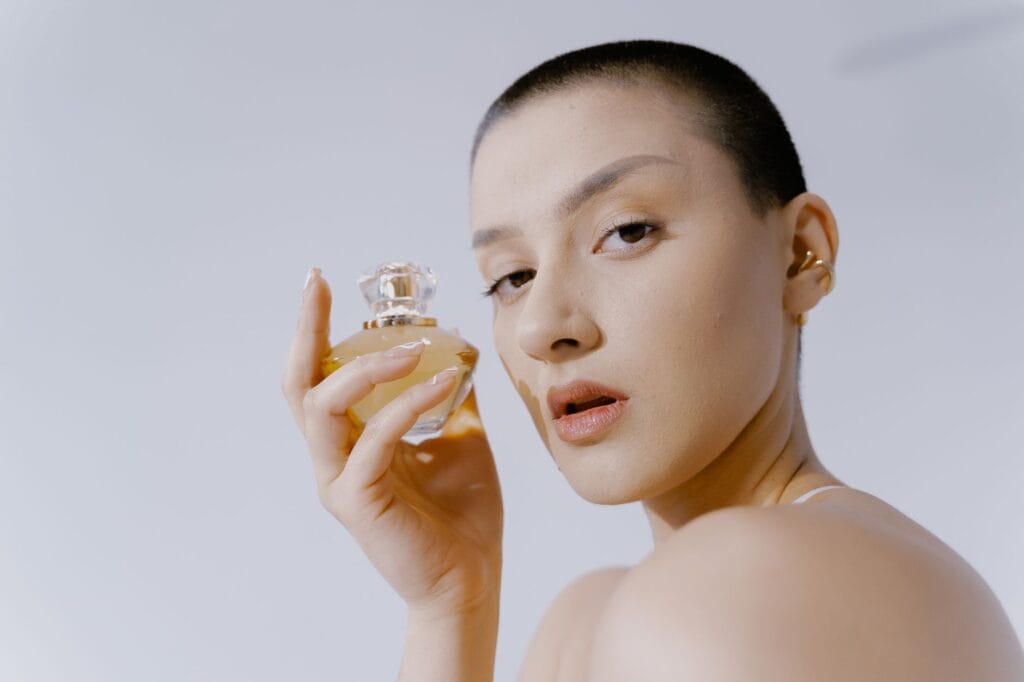 A diverse group of women holding luxury perfume bottles, representing the top 50 perfumes every woman should try in 2026.