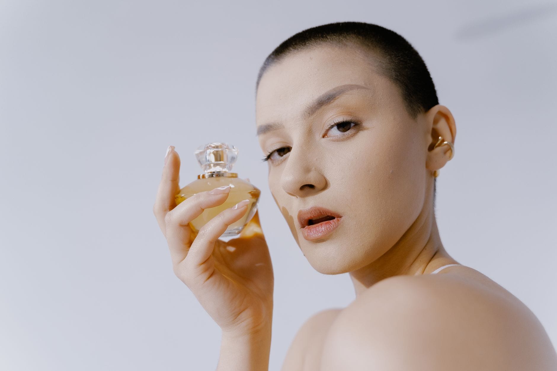 A diverse group of women holding luxury perfume bottles, representing the top 50 perfumes every woman should try in 2026.