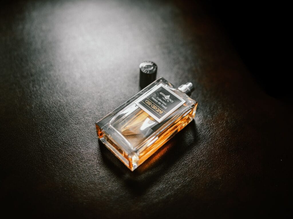 An artistic and unique perfume bottle surrounded by colorful abstract smoke, representing avant-garde fragrances.