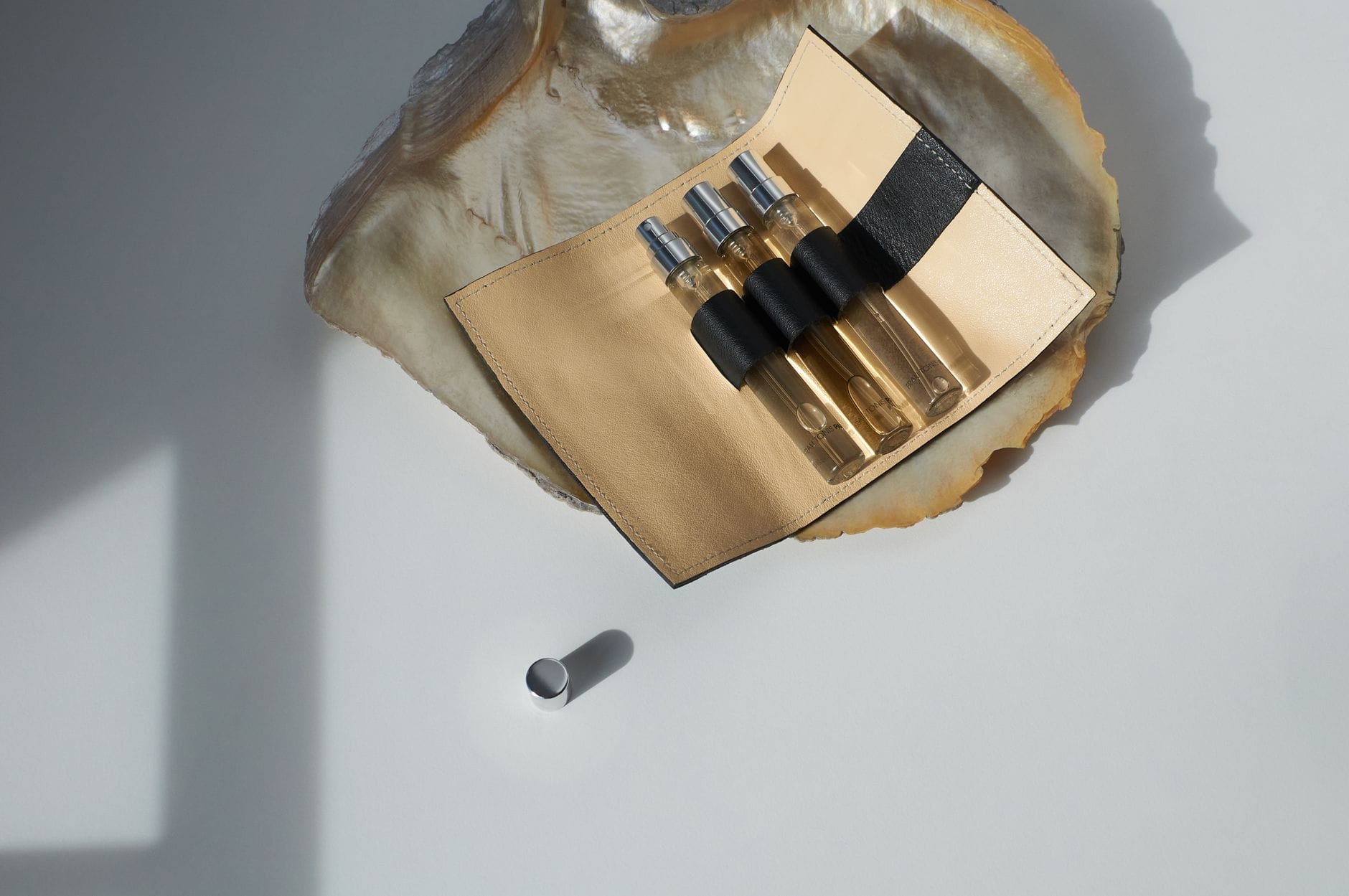 A collection of sleek, colorful travel-sized perfume subscription decants arranged on a modern vanity table.